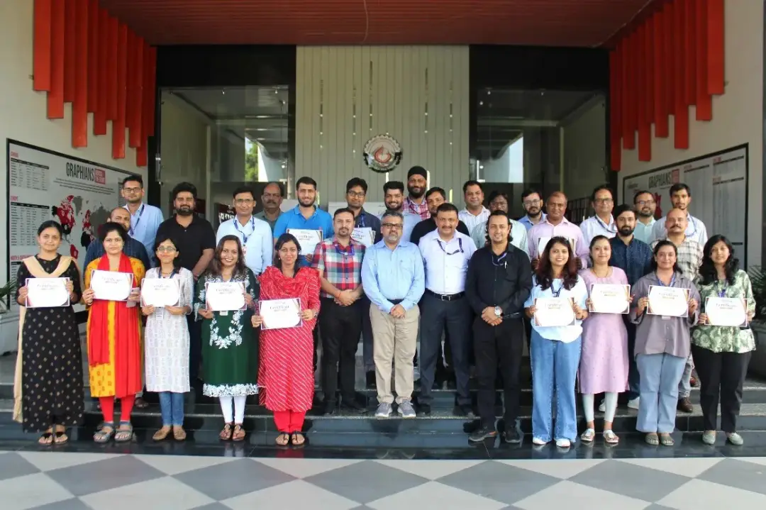 Group of professionals posing with certificates in front of a building entrance, celebrating achievement on steps and tiled floor.