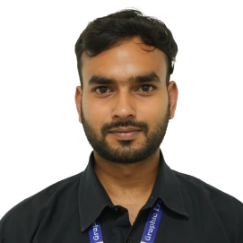 Head-and-shoulders portrait of a man with dark hair and a trimmed beard, wearing a black shirt and a blue lanyard, looking at the camera.