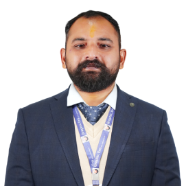 sandeep-abhishek-management-hld Portrait of a bearded man in a dark blue suit with a tie, wearing a conference lanyard and a tilak on his forehead.